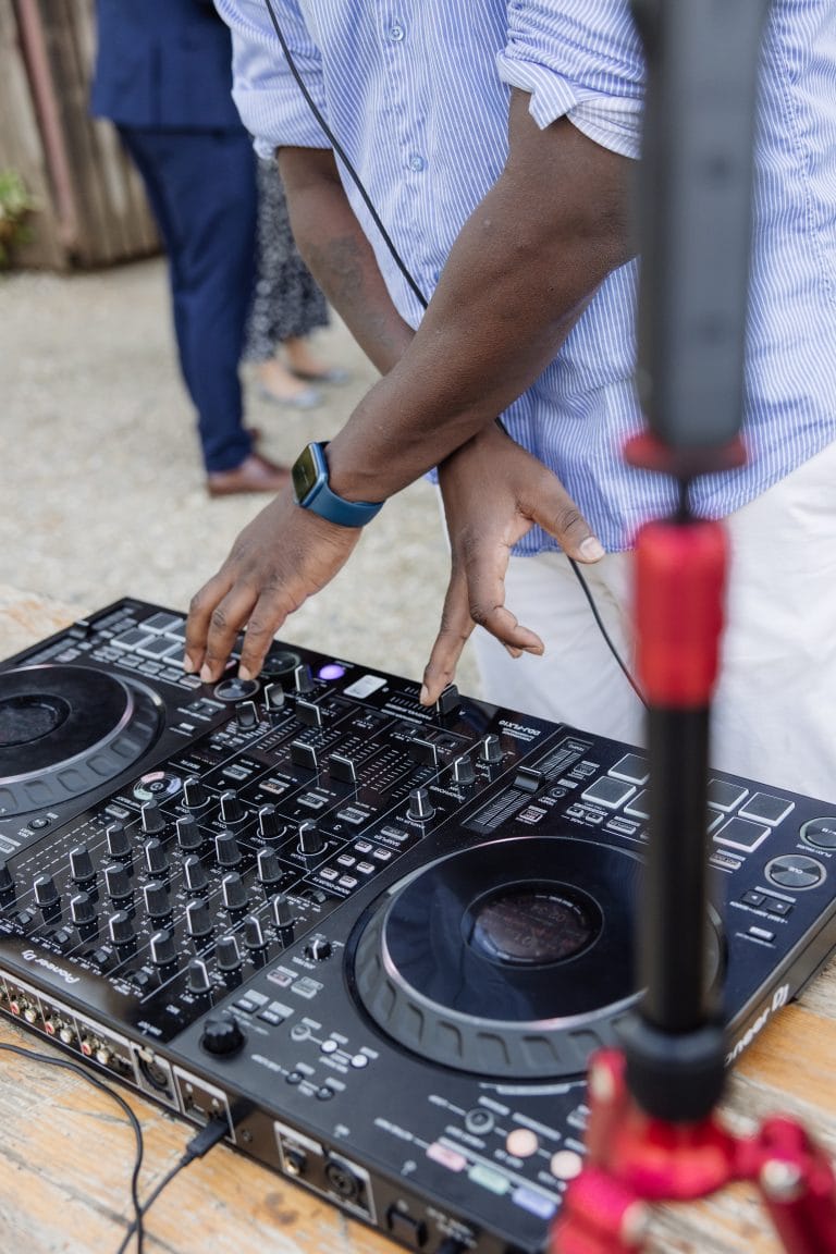 Gros plan sur les mains du DJ aux platines pendant un mariage