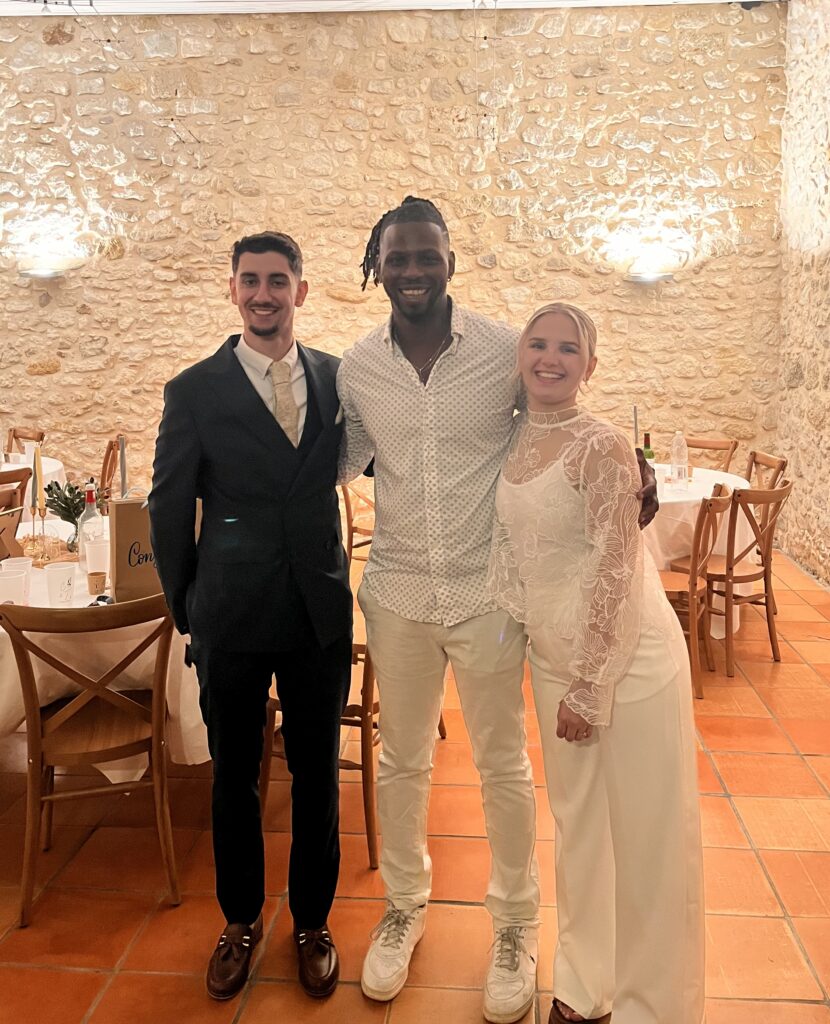 DJ Lexvolution avec les mariés dans une salle en pierre, après le repas