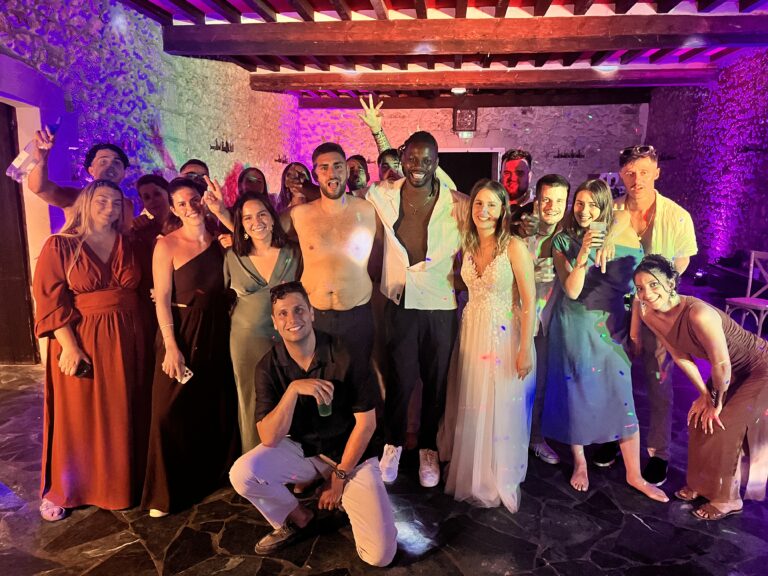 Les mariés et leurs invités posent avec DJ Lexvolution sur la piste de danse