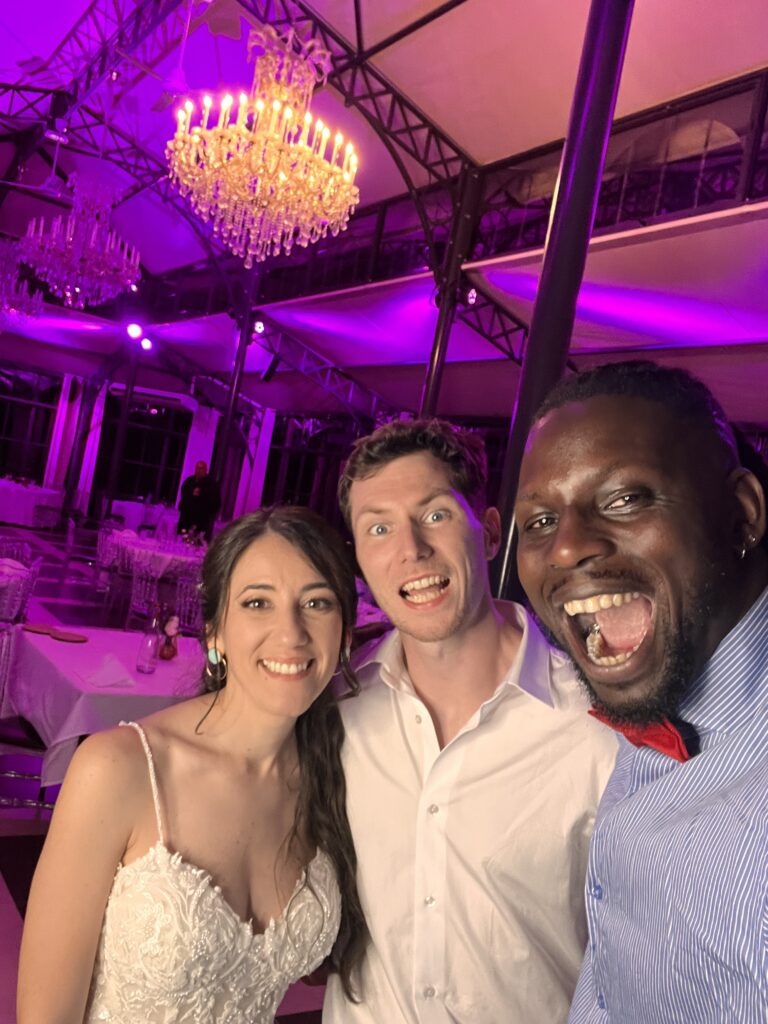 DJ Lexvolution en selfie avec les mariés sous un lustre, dans une salle en lumières violettes