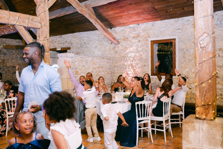 Invités debout et bras levés dans une salle en pierre, mariage animé par DJ Lexvolution
