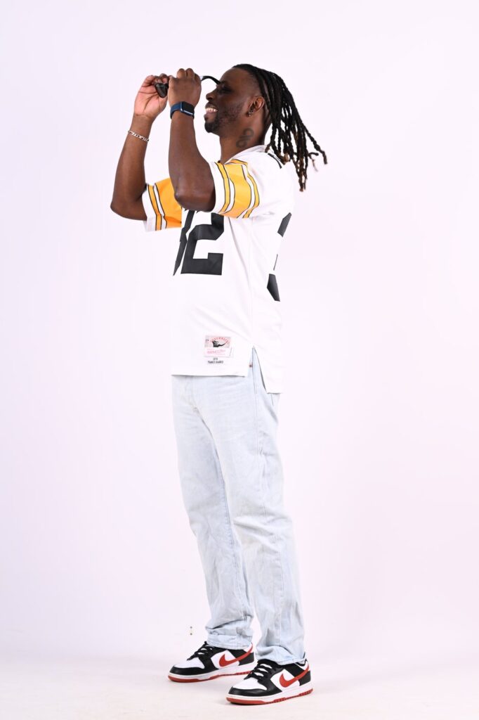DJ Lexvolution en studio, maillot de football americain, ajustant ses lunettes