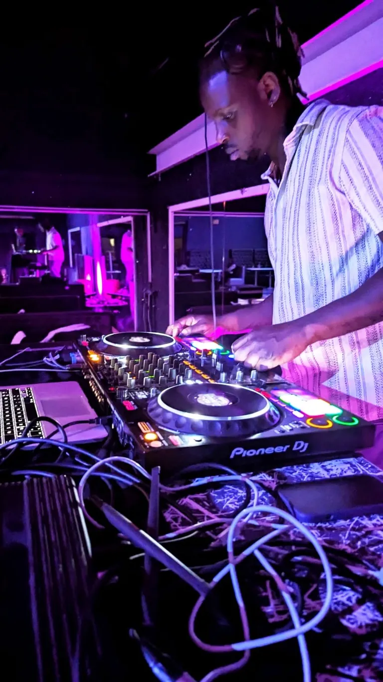 Alex, DJ Lexvolution, aux platines Pioneer pendant un mariage, sous une lumière violette