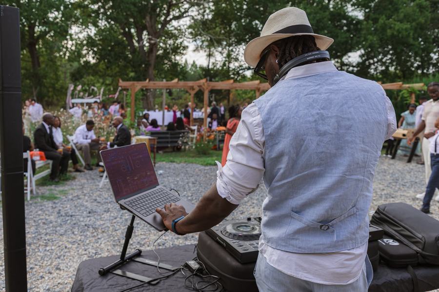 DJ Lexvolution sonorisant une ceremonie laique en exterieur, invites assis face a la pergola