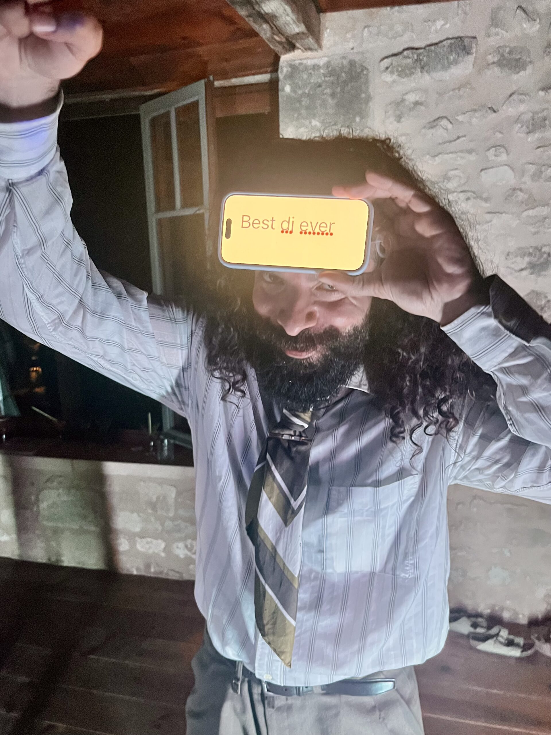 Un invité brandit un téléphone affichant « Best dj ever » pendant un mariage