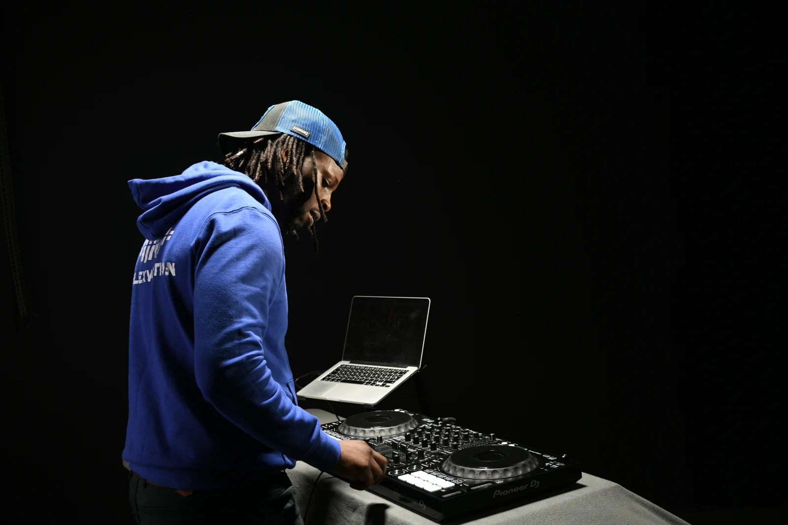 DJ Lexvolution en sweat bleu, mixant sur ses platines Pioneer