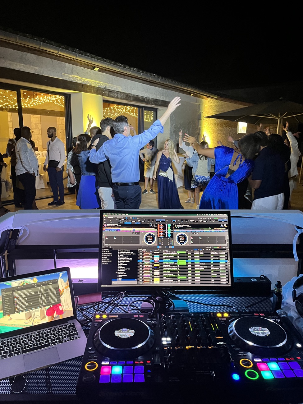 Vue depuis la régie DJ vers les invités dansant lors d’une soirée en extérieur